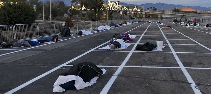Homeless people in Las Vegas sleeping outdoors in a parking lot
